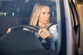 Pretty midle aged woman at the steering wheel of her car