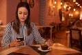 Pretty millenial in restaurant with phone