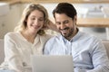 Pretty millennial couple enjoy carefree weekend on internet use laptop