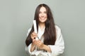 Pretty model woman straighten her hair with straightener on white background. Haircare concept Royalty Free Stock Photo