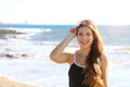 Pretty modern sporty woman with sunglasses on her head looking happy smiling at camera on the beach