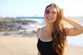 Pretty modern sporty woman with sunglasses looking happy smiling at camera on the beach