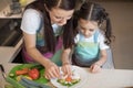 Pretty mother and her kid making vegetable salad