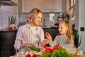 pretty mother and kid girl preparing healthy food for family, vegan salad Royalty Free Stock Photo