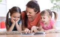 Pretty mother reading a book to her daughters.