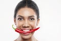 Pretty mulatto girl is eating spicy pepper Royalty Free Stock Photo