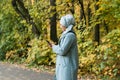 Pretty muslim woman using mobile phone outdoor. Arabic female wearing hijab using smartphone. Islamic girl texting a