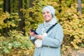 Pretty muslim woman using mobile phone outdoor. Arabic female wearing hijab using smartphone. Islamic girl texting a