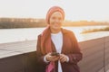 Muslim woman wearing hijab using mobile phone outdoor. Arabic woman wearing headscarf using smartphone on street