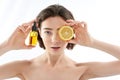 Pretty naked female with lemon and oil bottle