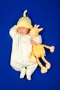 Pretty newborn baby boy sleeping on a blue blanket with little toy Royalty Free Stock Photo