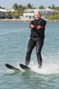 Pretty Older Lady Water Skiing by Nice House. Royalty Free Stock Photo