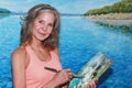 Pretty Older Woman Standing Holding a Paint Brush Painting a Large Lake Canvas