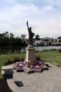 Pretty park near the river, depicting image of Little Lady Liberty surrounded by flowers and flags, Genesee, New York, 2022