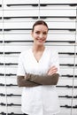 Pretty pharmacist with confidence. Portrait of confident young pharmacist smiling near shelf at pharmacy. Royalty Free Stock Photo