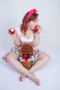 Pretty pin up caucasian young girl happy posing with red apples. cute vintage lady in retro dress having fun with fruits on white Royalty Free Stock Photo
