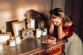 Pretty pin-up girl eats cake in retro interior. Temptation concept