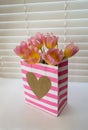 Pretty pink striped Valentine bag is filled with pink tulips Royalty Free Stock Photo