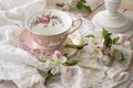 Pretty pink vintage afternoon tea party, tea cup and tender flowers on wooden tray and lace tablecloth