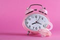 Pretty pink vintage retro style alarm clock with baby dummy pacificer Royalty Free Stock Photo