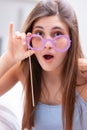 Pretty playful young woman holding purple glasses Royalty Free Stock Photo