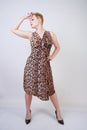 Pretty plus size young woman with short blonde hair wearing middle length  summer dress with animal leopard print. cute curvy woma Royalty Free Stock Photo