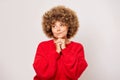 Pretty portrait of curly haired woman wearing red sweeter thinking looking left and smiling a bit, isolated on white Royalty Free Stock Photo