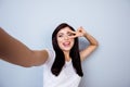 Pretty positive cheerful young woman making selfie showing two fingers