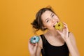 Pretty positive young woman eating colorful donuts Royalty Free Stock Photo