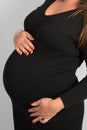 Pretty pregnant woman in black dress holding her belly Royalty Free Stock Photo