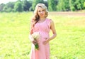 Pretty pregnant woman with chamomiles flowers in summer day Royalty Free Stock Photo