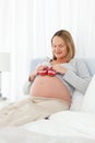 Pretty pregnant woman having baby shoes