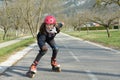 Pretty preteen girl on roller skates in helmet at a track