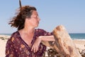 Pretty profile middle aged woman on summer beach curly brunette