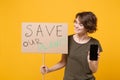 Pretty protesting woman hold protest broadsheet placard mobile phone with blank empty screen isolated on yellow