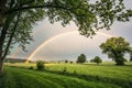 Pretty rainbow in a field with trees Royalty Free Stock Photo