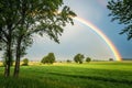 Pretty rainbow in a field with trees Royalty Free Stock Photo