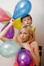 Pretty real family with color balloons on white background, blond woman with little boy at birthday party bright smiling Royalty Free Stock Photo