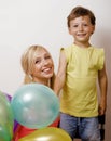 Pretty real family with color balloons on white background, blond woman with little boy at birthday party bright smiling Royalty Free Stock Photo