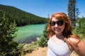 Pretty red hair female adult poses by Sparks Lake along the Cascade Lakes Scenic Byway Royalty Free Stock Photo