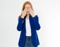 Pretty red hair woman covering her face with both hands, Young european girl in dark blue suit hides her face, studio photo Royalty Free Stock Photo