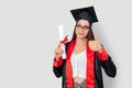 A pretty red haired female student, holding her study books and celebrating her graduation with success. Royalty Free Stock Photo