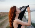 pretty red-haired woman in black dress outdoors posing fresh air Royalty Free Stock Photo