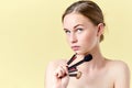 Pretty redhead teenager girl with blue eyes and freckles, looking away from camera, holding diverse make up brushes. Royalty Free Stock Photo