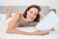 Pretty relaxed woman reading book in bed Royalty Free Stock Photo