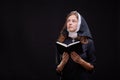 Pretty religious nun against dark background. Religion concept. Royalty Free Stock Photo