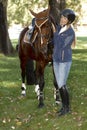 Pretty rider caressing horse Royalty Free Stock Photo