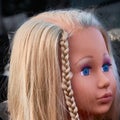 Pretty sad doll with blond hair, blue eyes and a plaited braid Royalty Free Stock Photo