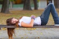 Pretty sad teenage girl lying on the bench Royalty Free Stock Photo