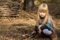 Pretty serious little blond girl playing outdoors